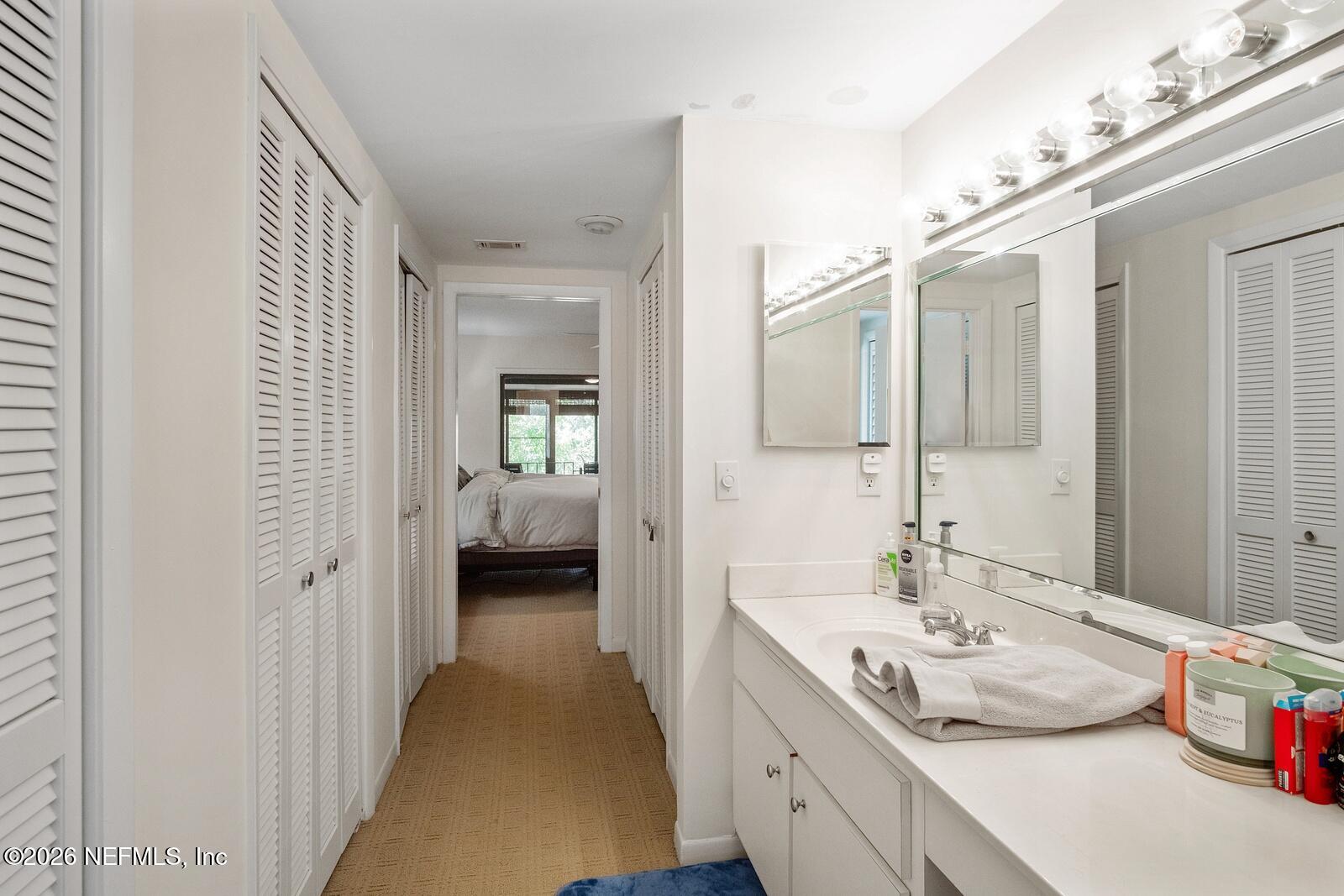8012 Hollyridge Road, Unit 17U Jacksonville, FL 32256 - Photo 13 of 22 a en suite bathroom with a double vanity sink and mirror