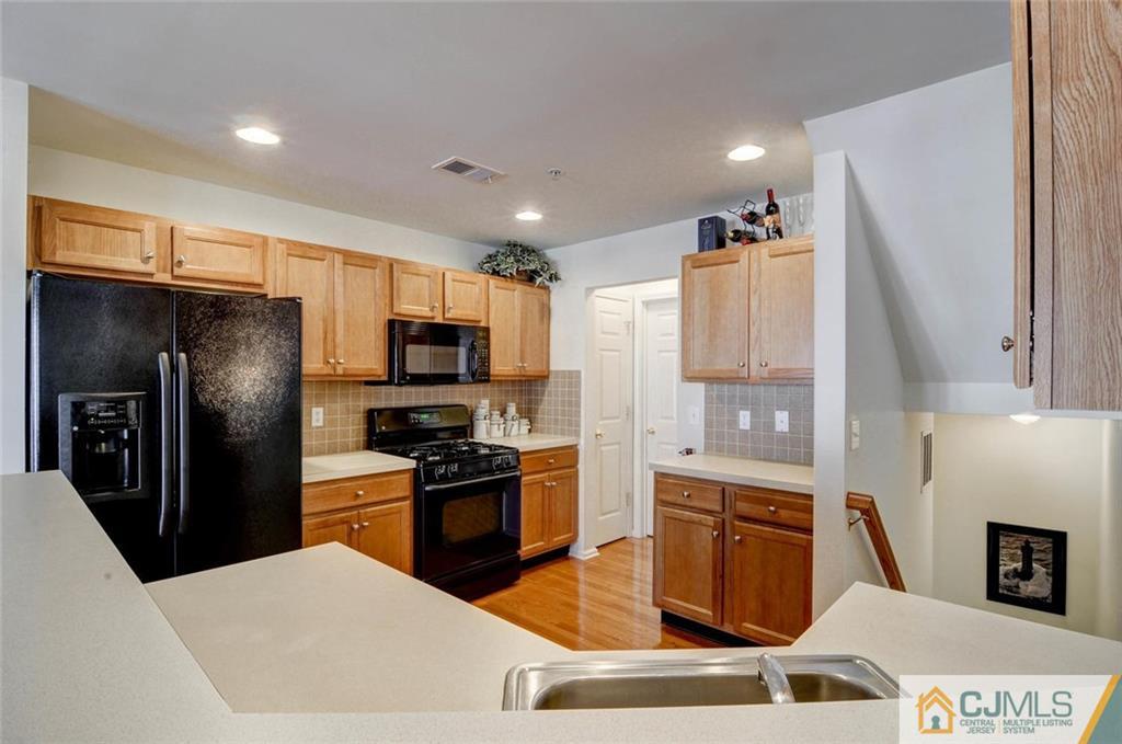 59 Raritan Reach Road, Unit 30 South Amboy, NJ 08879 - Photo 11 of 25 a kitchen with stainless steel appliances granite countertop a refrigerator a stove top oven a sink and dishwasher