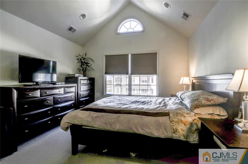 59 Raritan Reach Road, Unit 30 South Amboy, NJ 08879 - Photo 16 of 25 a bedroom with a bed and a flat tv screen on dresser