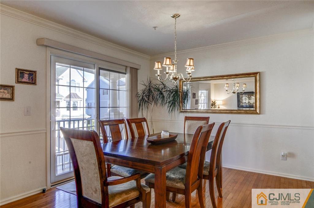 59 Raritan Reach Road, Unit 30 South Amboy, NJ 08879 - Photo 8 of 25 a view of a dining room with furniture wooden floor and chandelier