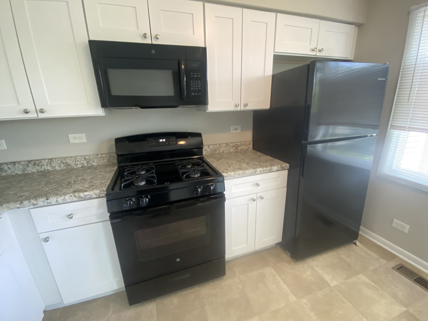1920 Georgetown Lane Hoffman Estates, IL 60169 - Photo 15 of 28 a kitchen with stainless steel appliances white cabinets and a stove a refrigerator with wooden cabinets