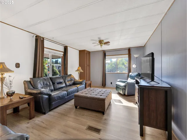 a living room with furniture flat screen tv and large window