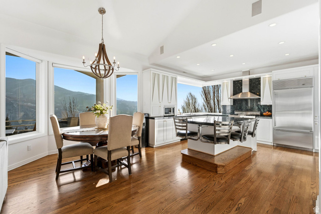 1878 East Ridge Point Drive Bountiful, UT 84010 - Photo 10 of 92 Dining room featuring vaulted ceiling, light wood-style flooring, hanging lights, and a mountain view