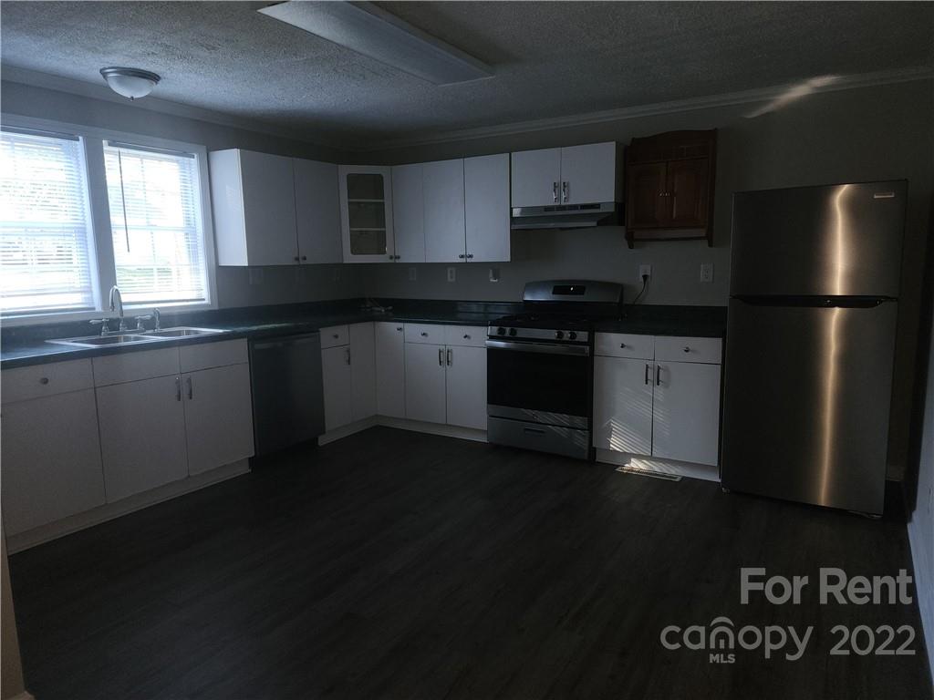 307 Rice Street Kannapolis, NC 28081 - Photo 4 of 7 a kitchen with granite countertop stainless steel appliances and sink