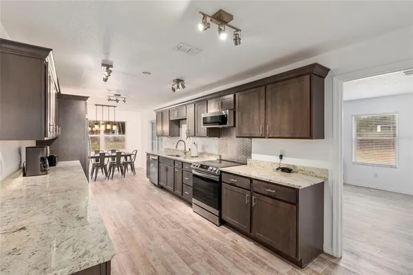 a kitchen with stainless steel appliances kitchen island granite countertop a sink counter space and cabinets