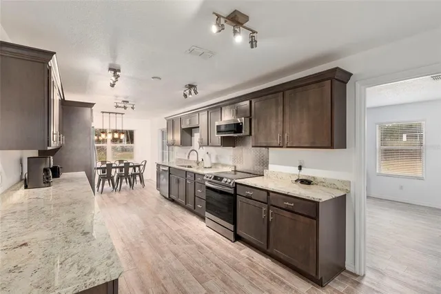 a kitchen with stainless steel appliances kitchen island granite countertop a sink counter space and cabinets