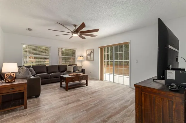 a living room with furniture a large window and a flat screen tv