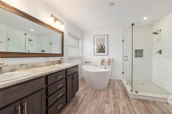 a spacious bathroom with a granite countertop sink mirror and shower