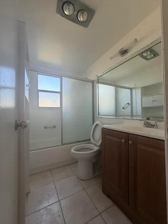 a bathroom with a toilet sink vanity and mirror