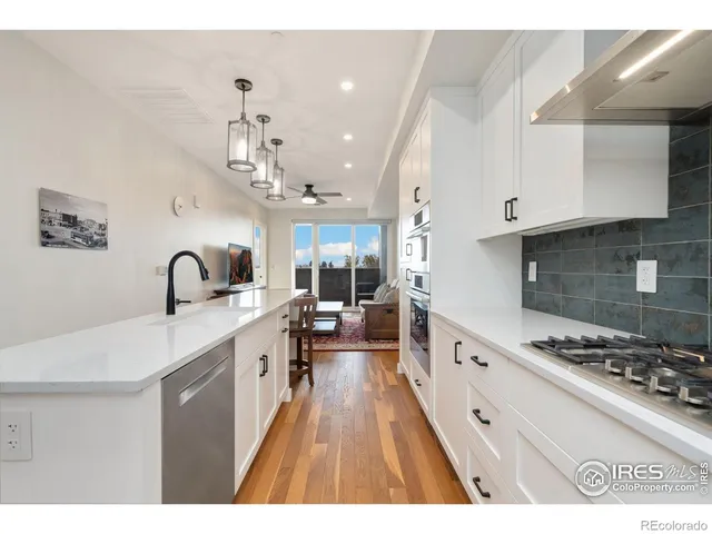 a large kitchen with kitchen island a sink a stove and cabinets
