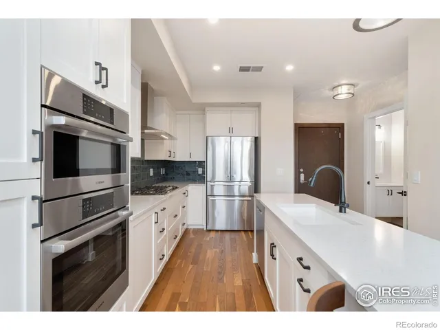 a kitchen with stainless steel appliances kitchen island granite countertop a refrigerator and a stove top oven