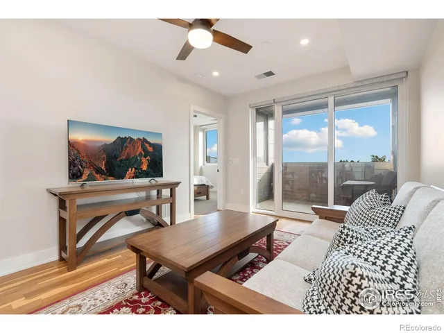 a living room with furniture a rug and a flat screen tv
