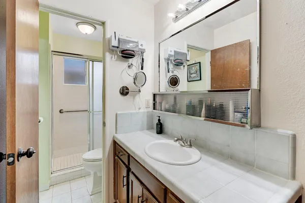 a bathroom with a sink a toilet and shower