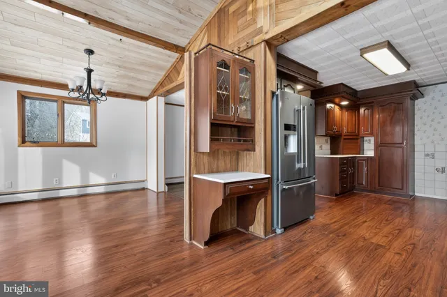 a view of a kitchen with a refrigerator and wooden floor
