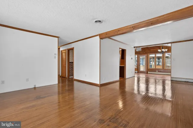 a view of empty room with wooden floor