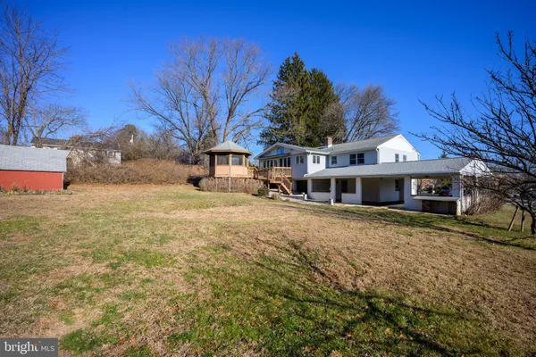 a front view of a house with a yard covered with snow and trees