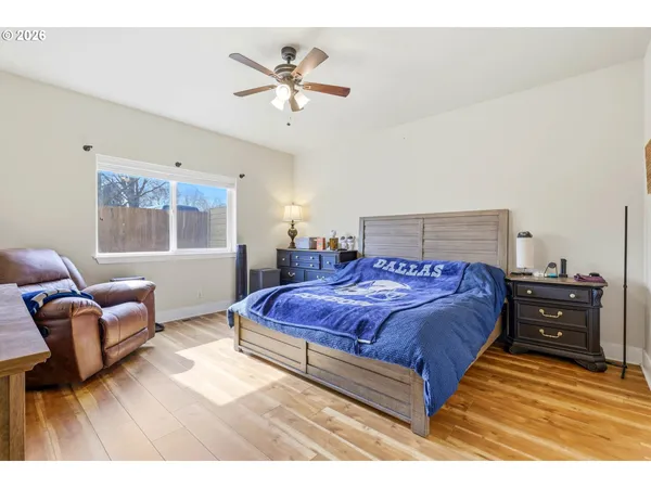 a spacious bedroom with a bed a chandelier and couch