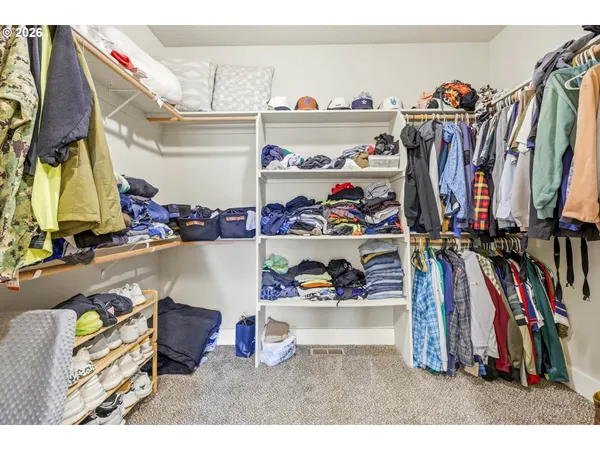 a view of walk in closet with clothes and shoes
