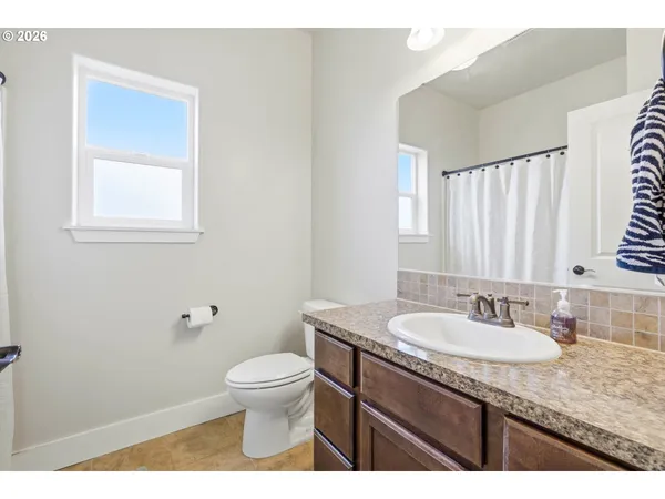 a bathroom with a granite countertop sink a toilet and a mirror