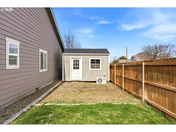a view of a backyard with a large window and wooden fence