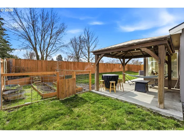 a view of a backyard with table and chairs under an umbrella with a small yard