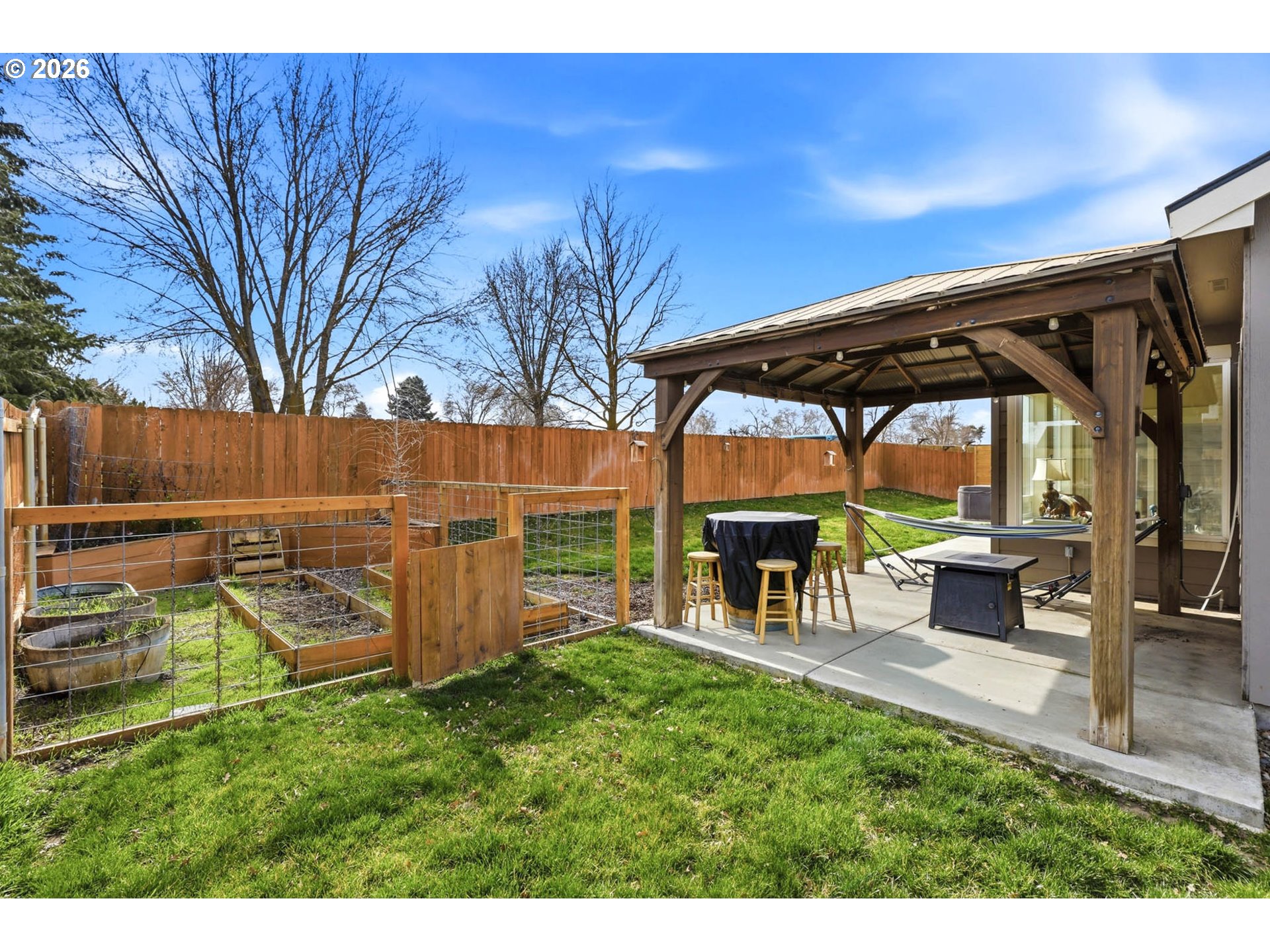 1003 Southwest Olive Court Hermiston, OR 97838 - Photo 27 of 34 a view of a backyard with table and chairs under an umbrella with a small yard