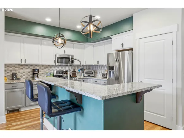 a kitchen with stainless steel appliances granite countertop a sink a stove and a refrigerator