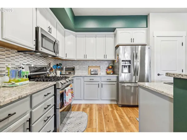 a kitchen with stainless steel appliances granite countertop a refrigerator a stove top oven a sink and dishwasher