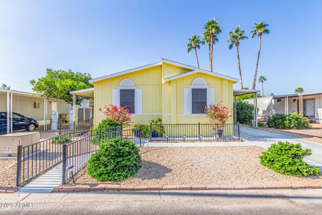a view of a house with a yard and potted plants