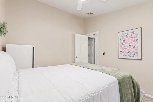 a bedroom with a bed and painting on the wall