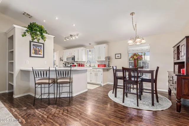 a dining room with furniture a chandelier and wooden floor