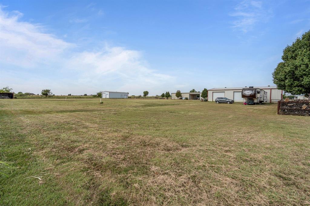 6501 Indian Trail Sanger, TX 76266 - Photo 32 of 39 View of grassy yard featuring a garage, an outdoor structure, and a rural view
