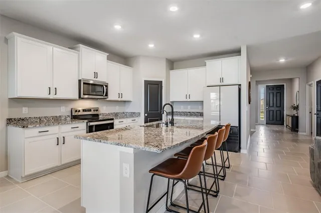 a kitchen with stainless steel appliances kitchen island granite countertop a sink and cabinets