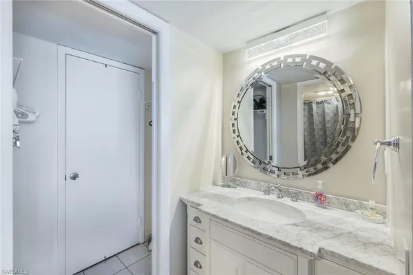 a bathroom with a granite countertop vanity a mirror and vanity