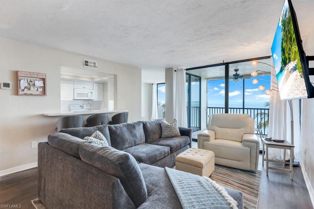10475 Gulf Shore Drive, Unit 142 Naples, FL 34108 - Photo 3 of 14 a living room with furniture and a large window