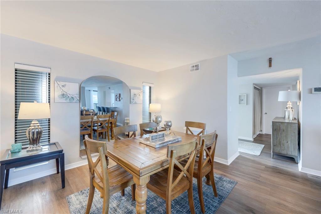 10475 Gulf Shore Drive, Unit 142 Naples, FL 34108 - Photo 8 of 14 a view of a dining room with furniture and wooden floor