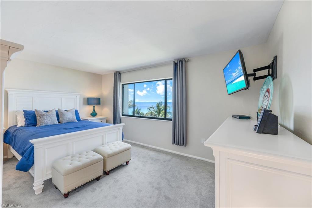 10475 Gulf Shore Drive, Unit 142 Naples, FL 34108 - Photo 9 of 14 a bedroom with a bed and a flat screen tv