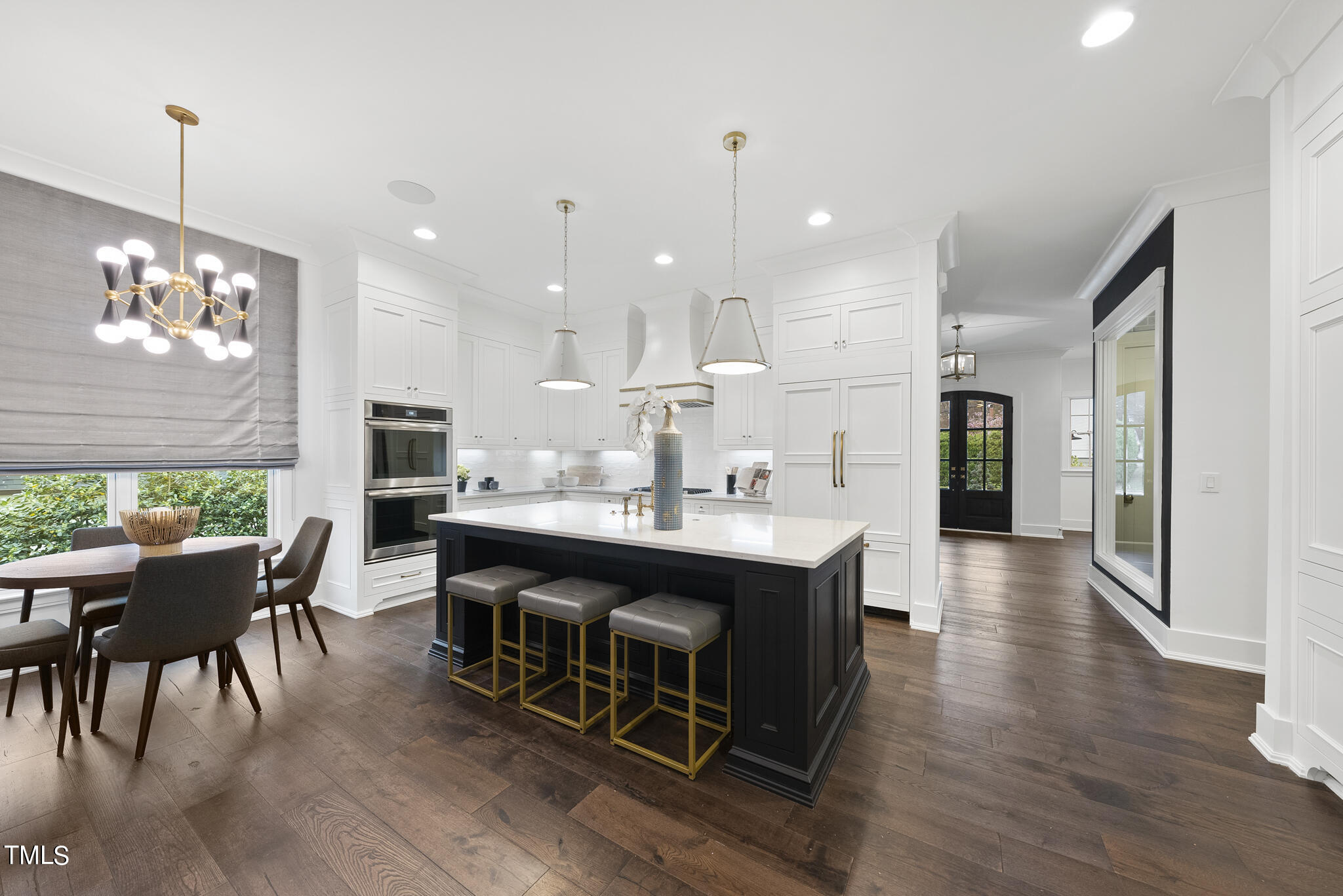 115 Edenburgh Road Raleigh, NC 27608 - Photo 12 of 50 a large kitchen with kitchen island a dining table chairs and a chandelier