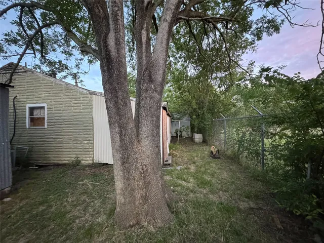 a view of a house with a yard and tree