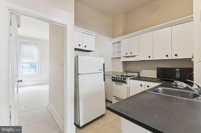 a kitchen with a refrigerator a stove a microwave and cabinets