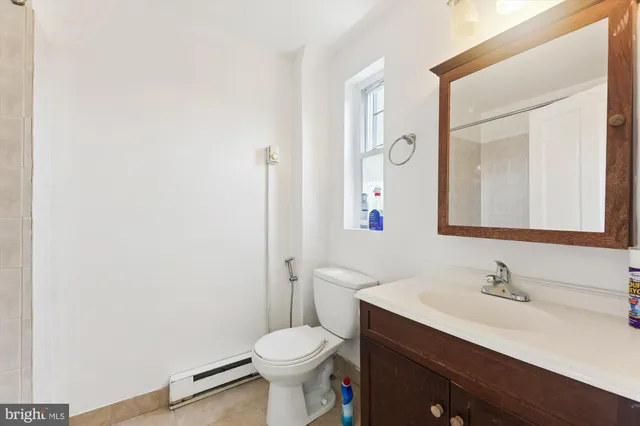 a bathroom with a sink vanity mirror and toilet