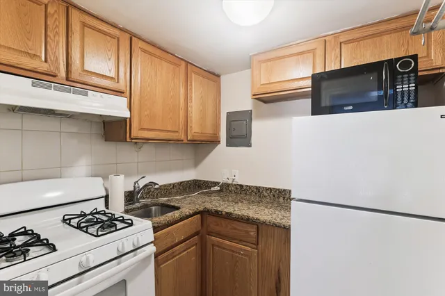 a kitchen with stainless steel appliances granite countertop a stove and a microwave