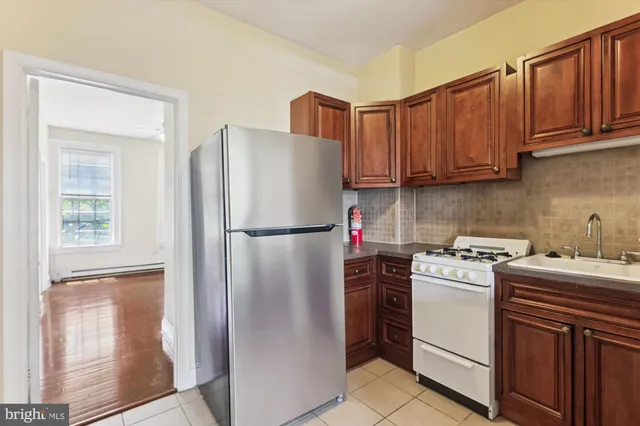 a kitchen with a refrigerator sink stove and cabinets