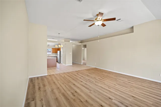 a view of a livingroom with wooden floor and a ceiling fan