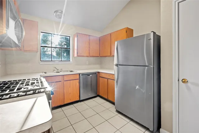 a kitchen with a refrigerator a stove a sink and a window