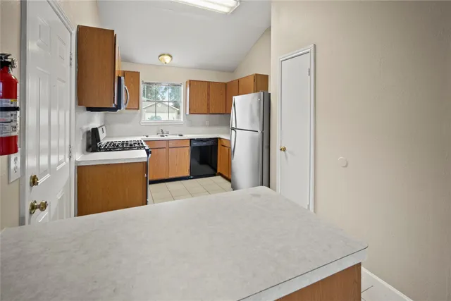 a kitchen with a refrigerator a stove top oven a sink and dishwasher