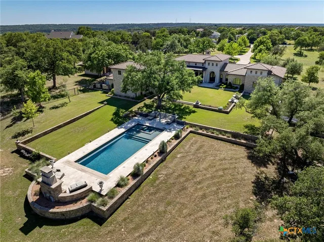 a view of a tennis ground with large trees