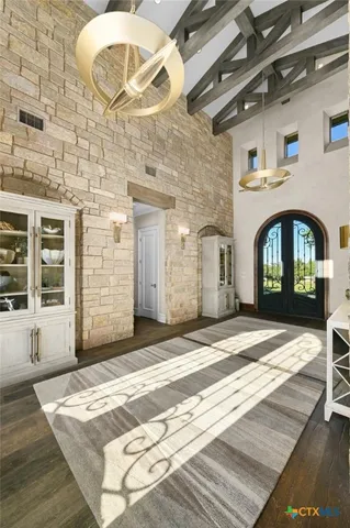 a living room with furniture a chandelier and a large mirror