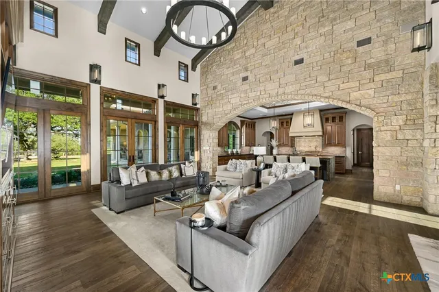 a large white kitchen with a large island in the center windows and furniture