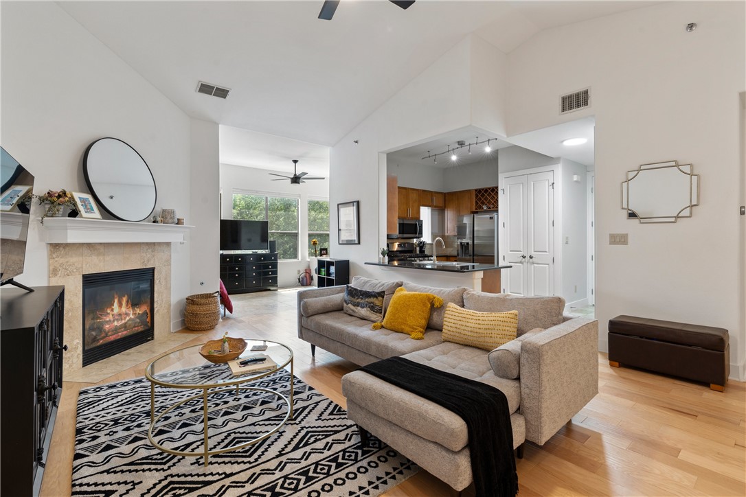 2216 Thornton Road, Unit 430 Austin, TX 78704 - Photo 1 of 1 a living room with furniture a fireplace and a chandelier